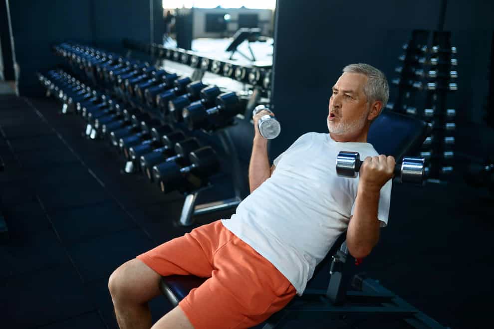 2H3MK2F Elderly man, workout with dumbbells on bench, gym
