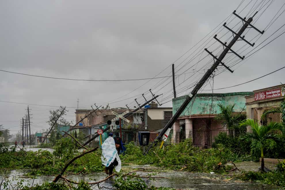Fallen utility poles and branches line a street after Hurricane Ian hit Pinar del Rio, Cuba (Ramon Espinosa/AP)