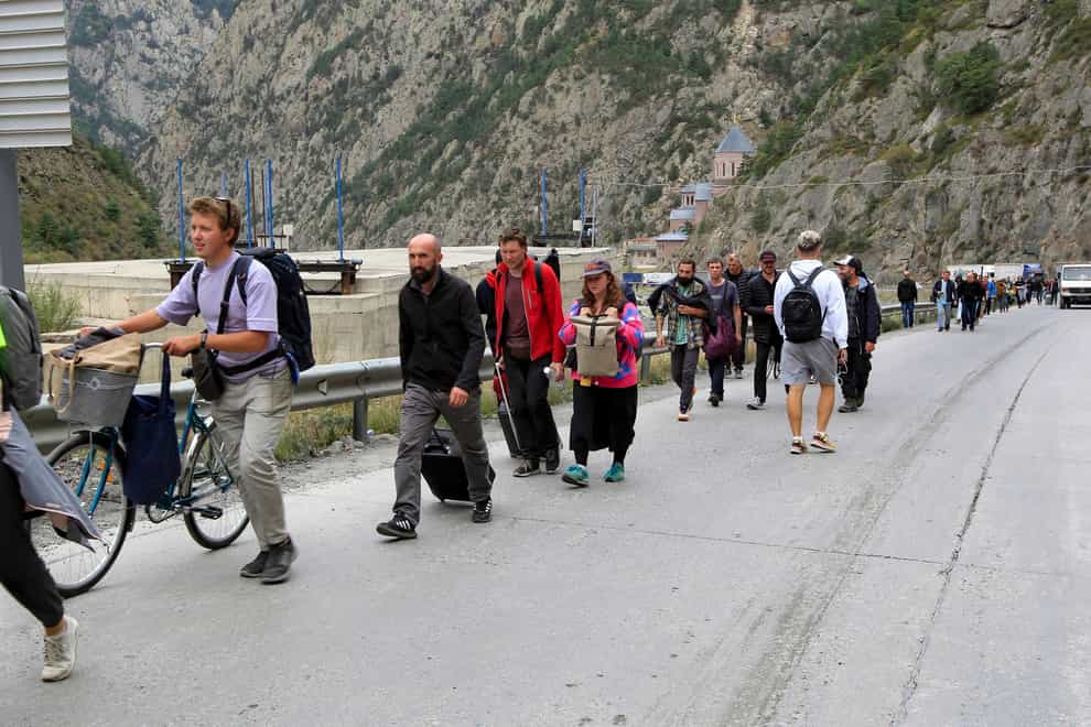 People walk towards the border crossing between Georgia and Russia (AP Photo)