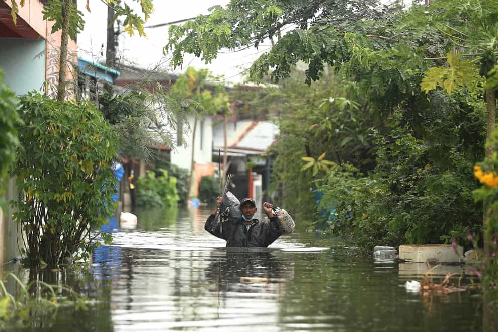 A resident wades through floodwaters in the Ubon Ratchathani province, north-eastern Thailand (Nava Sangthong/AP)