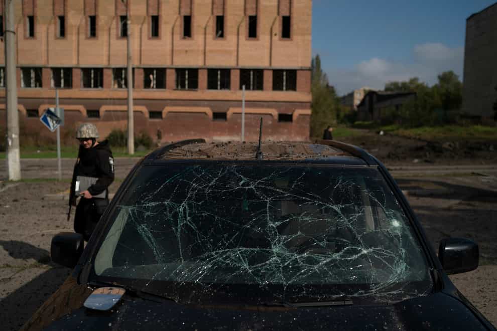 A police officer walks past a damaged car after a Russian attack in Kramatorsk (AP)