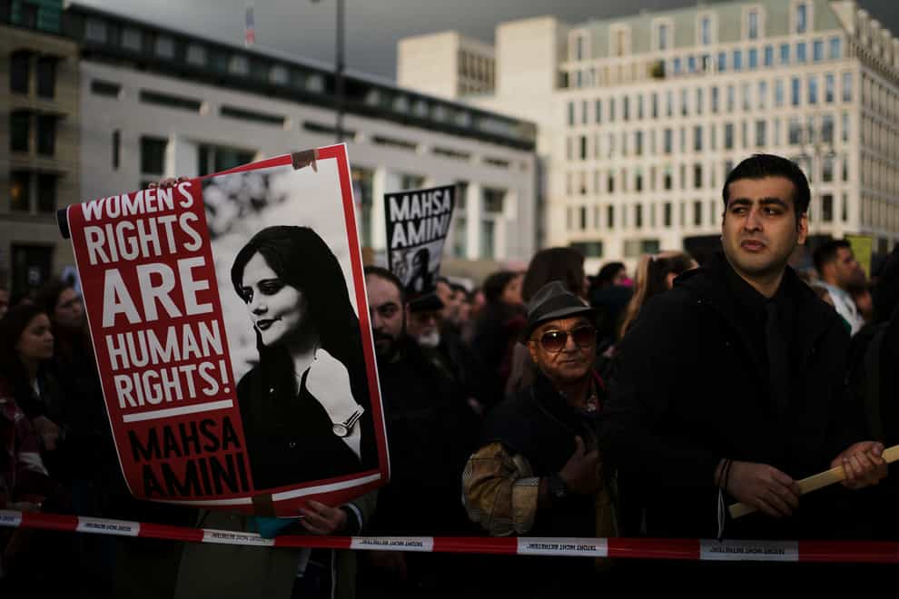 Demonstrators display posters as they attend a protest against the death of Iranian Mahsa Amini in Berlin, Germany, Wednesday, Sept. 28, 2022. Amini, a 22-year-old woman who died in Iran while in police custody, was arrested by Iran’s morality police for allegedly violating its strictly-enforced dress code. (AP Photo/Markus Schreiber)