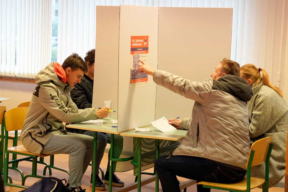 Latvians mark their ballots at a polling station in Riga (Roman Koksarov/AP/PA)