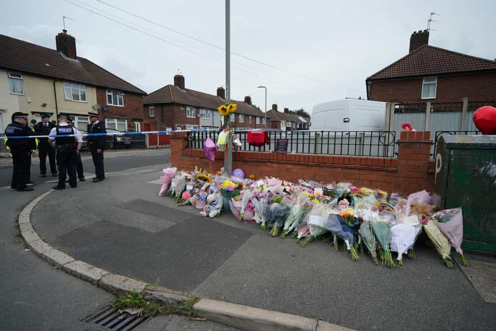 Flowers are left near to the scene of an incident in Kingsheath Avenue (Peter Byrne/PA)