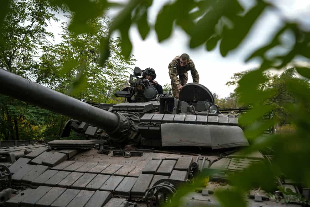 Ukrainian servicemen sit on T-80 tank that they claimed had been captured from the Russian army in Bakhmut, Ukraine (AP)