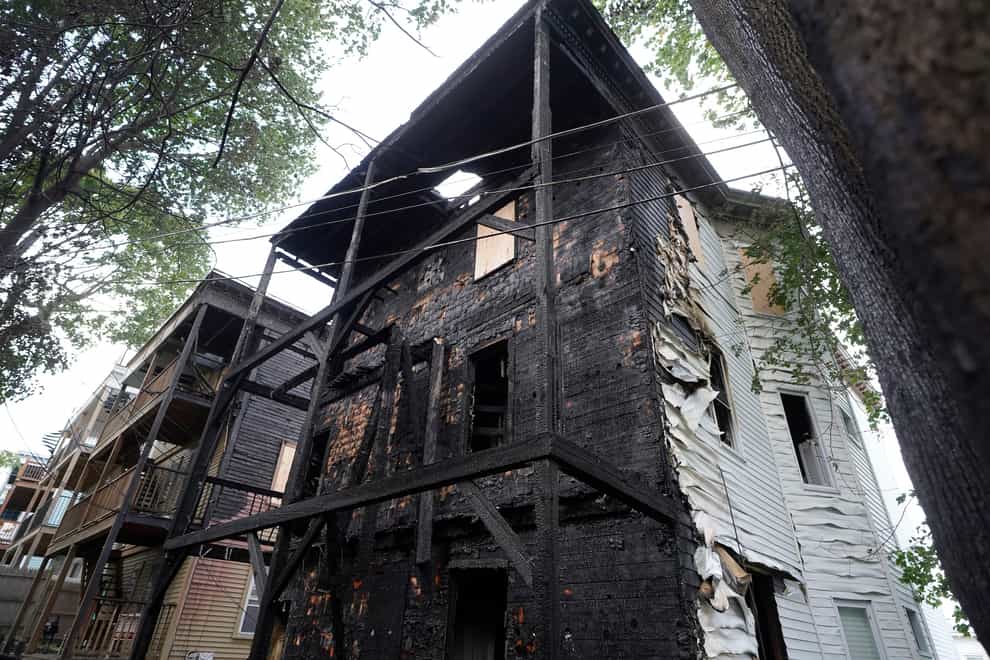 The fire-damaged back of a triple decker at 25 Peverell Street in Boston’s Dorchester (AP)