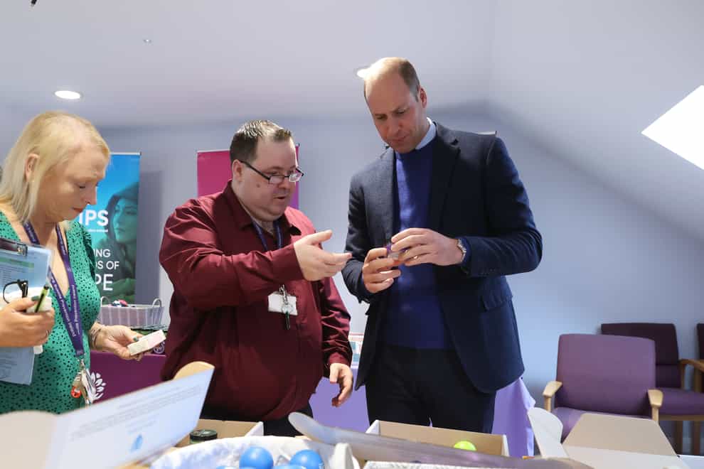 The Prince of Wales speaks to a volunteer about the contents of the Little Boxes of Hope during a visit to PIPS Suicide Prevention (PIPS Charity) in Belfast which works across communities in the city and throughout Northern Ireland to provide crisis support for those at risk of suicide and self-harm, as part of the royal visit to Northern Ireland. Picture date: Thursday October 6, 2022.