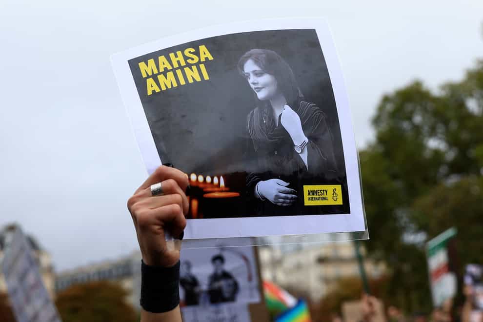 A protester shows a portrait of Mahsa Amini during a demonstration to support Iranian protesters standing up to their leadership over the death of a young woman in police custody, Sunday, Oct. 2, 2022 in Paris. Thousands of Iranians have taken to the streets over the last two weeks to protest the death of Mahsa Amini, a 22-year-old woman who had been detained by Iran’s morality police in the capital of Tehran for allegedly not adhering to Iran’s strict Islamic dress code (Aurelien Morissard/AP/PA)