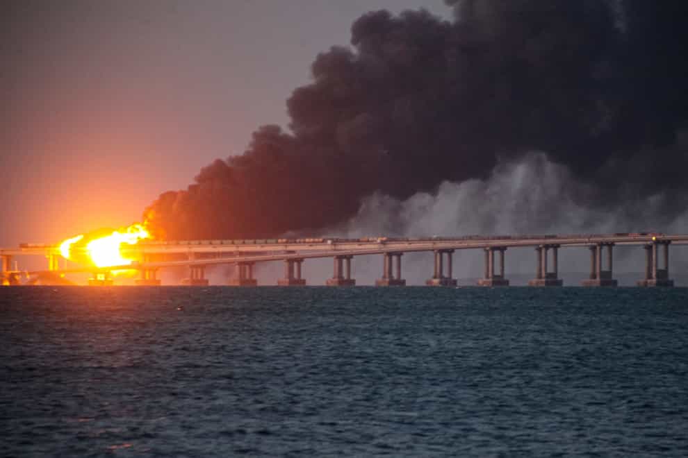 Flame and smoke rise fron Crimean Bridge connecting Russian mainland and Crimean peninsula over the Kerch Strait, in Kerch, Crimea, Saturday, Oct. 8, 2022. Russian authorities say a truck bomb has caused a fire and the partial collapse of a bridge linking Russia-annexed Crimea with Russia. Three people have been killed. The bridge is a key supply artery for Moscow’s faltering war effort in southern Ukraine (AP/PA)