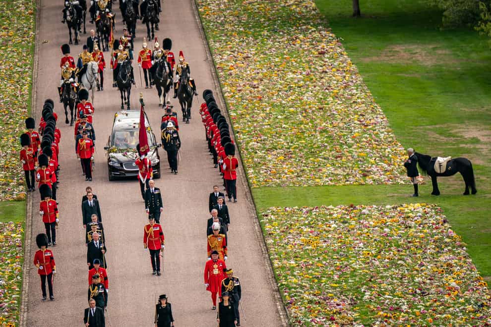 Emma, the monarch’s fell pony, standing besides floral tributes as the Ceremonial Procession of the coffin carrying the Queen arrived at Windsor Castle for her Committal Service at St George’s Chapel (PA)