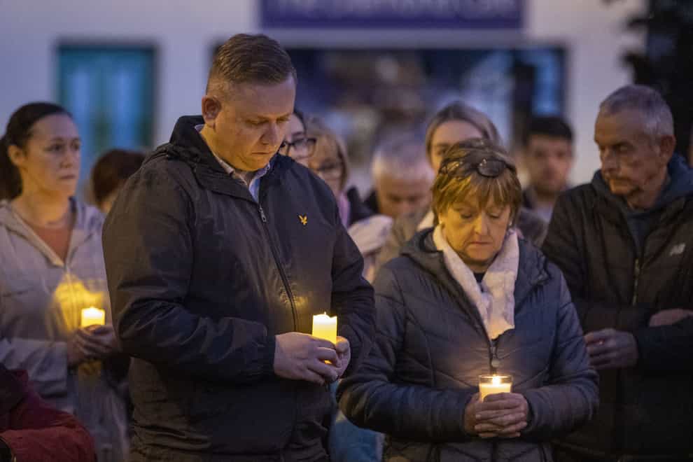 Mourners hold candles during a moment of silence in Castlefinn, Co Donegal, at the vigil for victims of an explosion at the Applegreen filling station in Creeslough (PA)