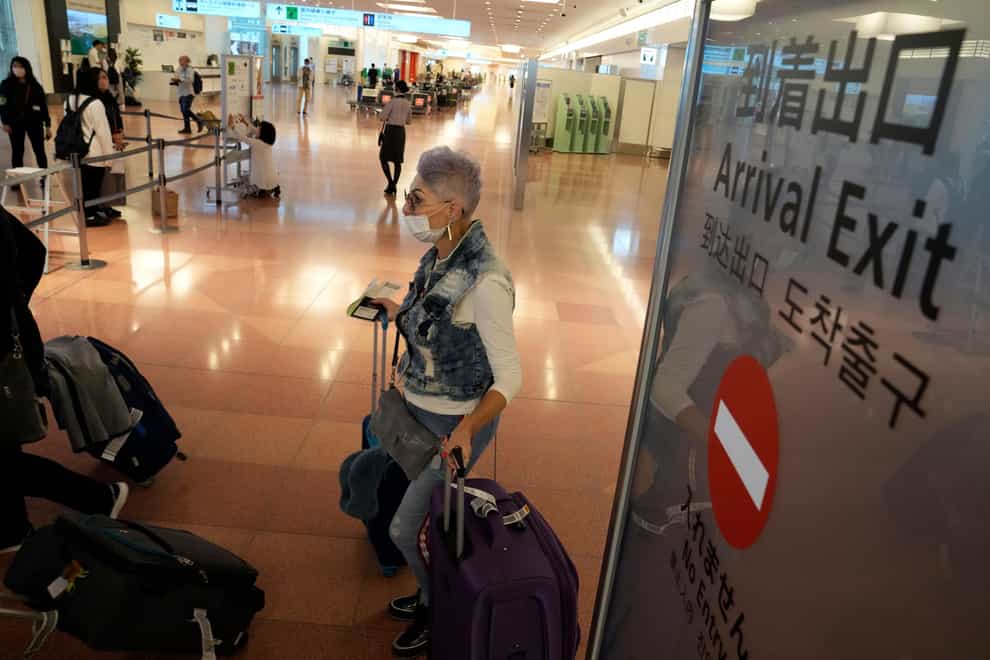 A foreign traveller arrives at Haneda Airport in Tokyo (Eugene Hoshiko/AP)