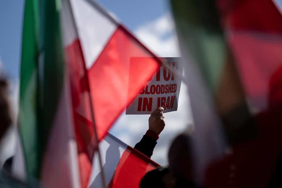 A protester holds a placard reading ‘Stop Bloodshed in Iran’ during a demonstration of thousands who showed their support for Iranian protesters standing up to their leadership over the death of a young woman in police custody, in The Hague, Netherlands (Peter Dejong/AP)