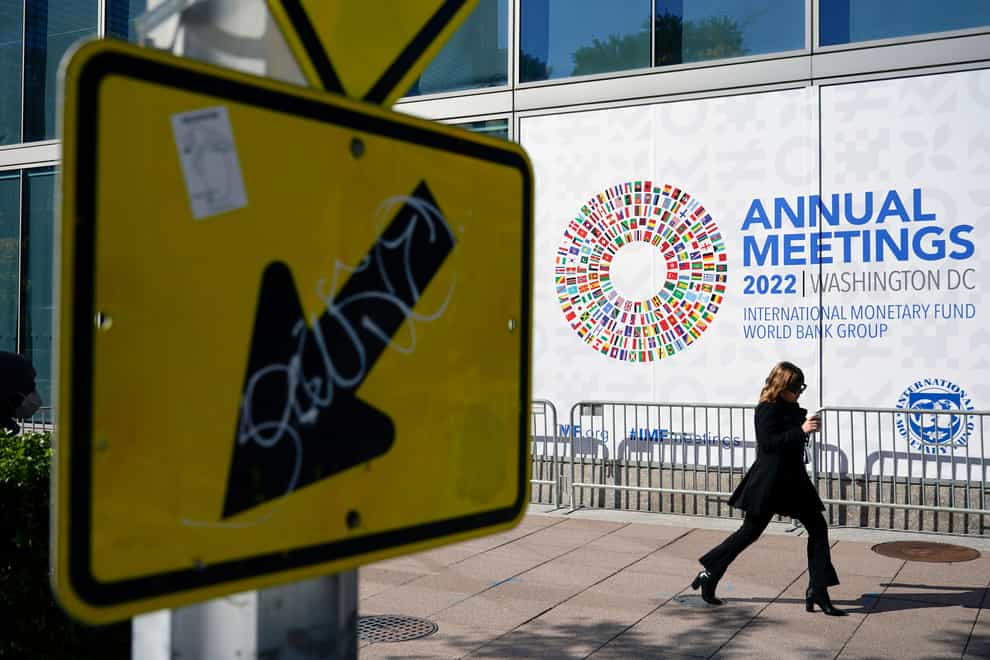 An attendee walks outside the 2022 Annual Meetings of the International Monetary Fund and the World Bank Group in Washington (Patrick Semansky/AP)
