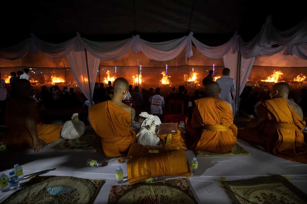 Monks watch the funeral pyres (Wason Wanichakorn/AP)