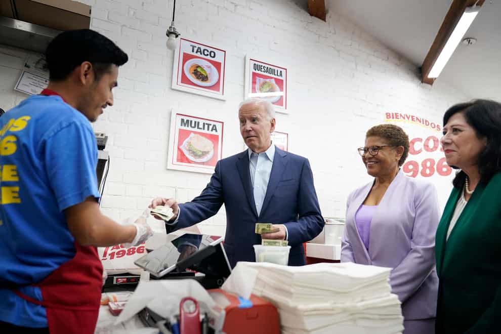 President Joe Biden pays for a takeout order at Tacos 1986, a Mexican restaurant, in Los Angeles (AP)