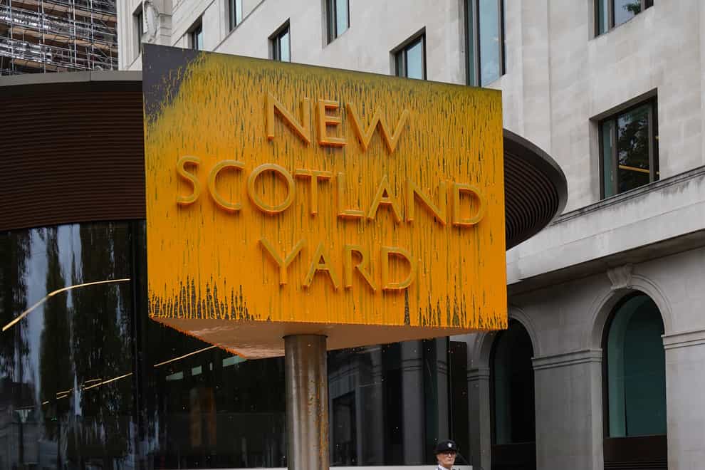 A Just Stop Oil protester spray painted a sign outside New Scotland Yard in London (Stefan Rousseau/AP)
