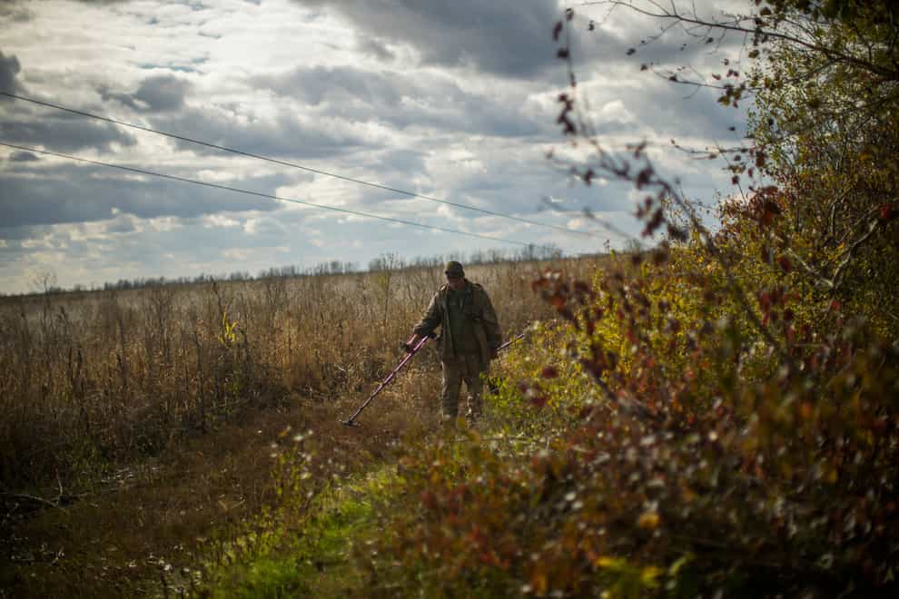 A Ukrainian territorial defence deminer searches for mines near Hrakove village (Francisco Seco/AP)