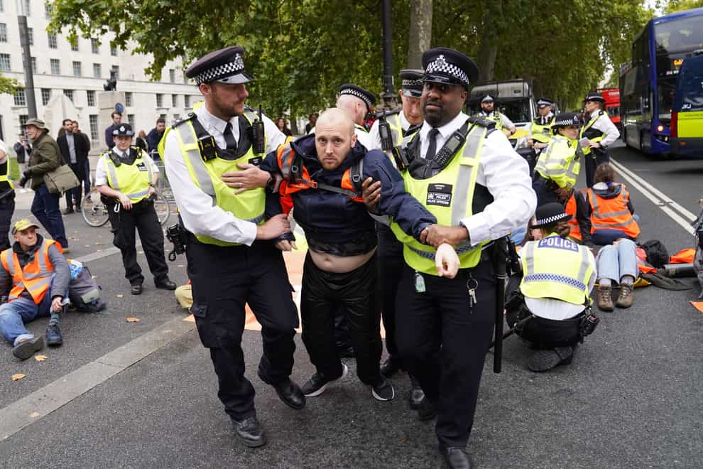 Police officers detain a Just Stop Oil protester outside New Scotland Yard in London on Friday (Stefan Rousseau/PA)