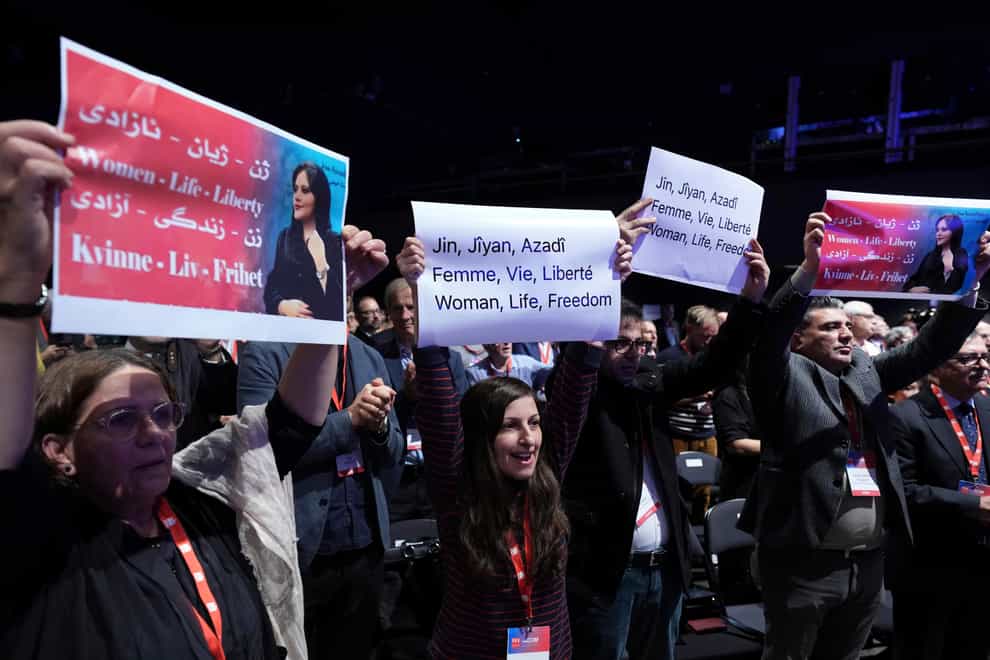 People hold protest poster during a congress of the Party of European Socialists in Berlin, Germany, against the government in Iran in memory of Mahsa Amini (AP)