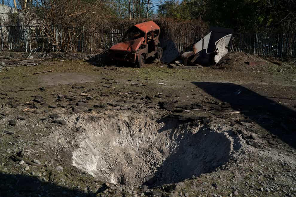 A destroyed car is seen next to a crater created by an explosion after a Russian attack in Zaporizhzhia, Ukraine (Leo Correa/AP)