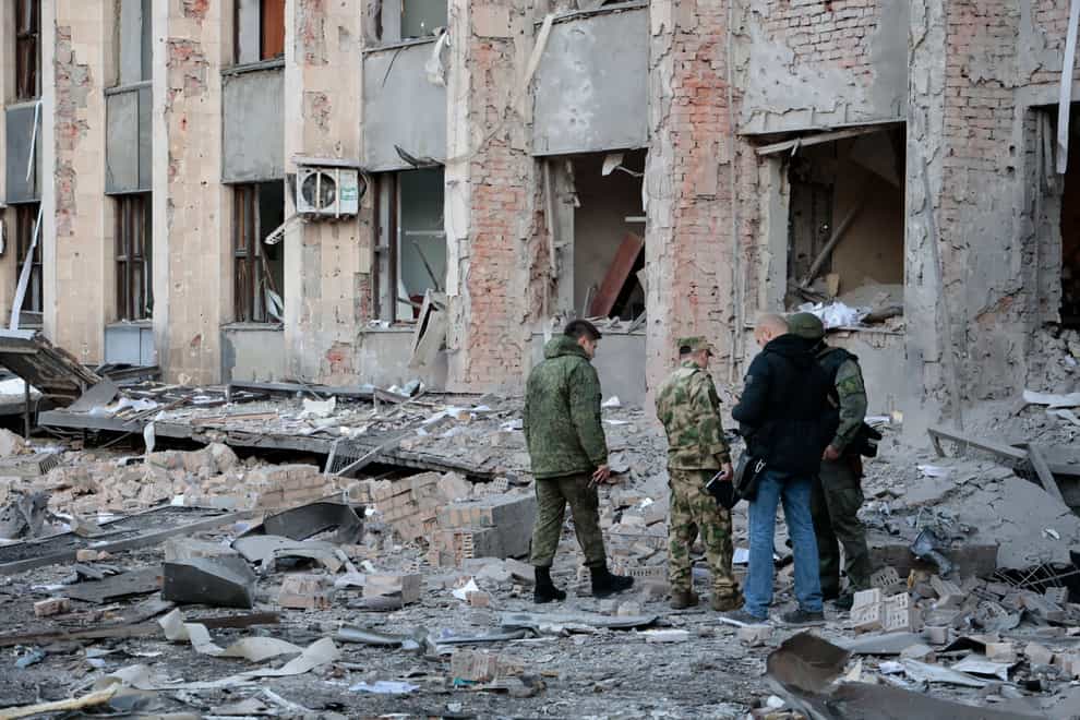 Investigators inspect a site after shelling near an administrative building in Donetsk, eastern Ukraine (Alexei Alexandrov/AP)