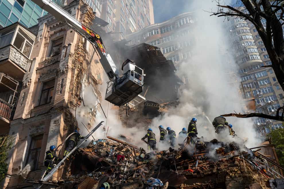 Firefighters work after a drone attack on buildings in Kyiv, Ukraine, on Monday October 17 2022 (Roman Hrytsyna/AP)