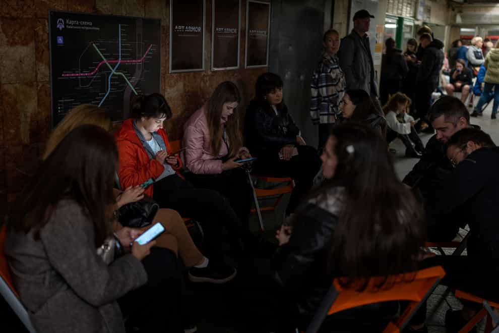 People sit in a Kyiv subway which is being used as a bomb shelter (Emilio Morenatti/AP)