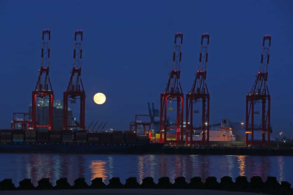 The moon rises behind the cranes of Peel Ports in Liverpool (Peter Byrne/PA)