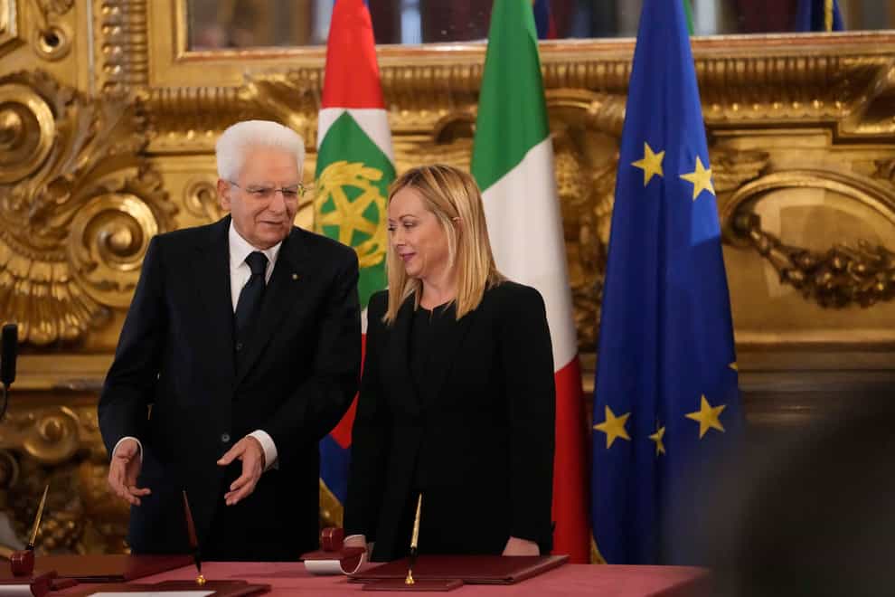 Italian President Sergio Mattarella is flanked by newly appointed Italian Premier Giorgia Meloni during the swearing in ceremony at the Quirinal presidential palace in Rome (Alessandra Tarantino/AP)