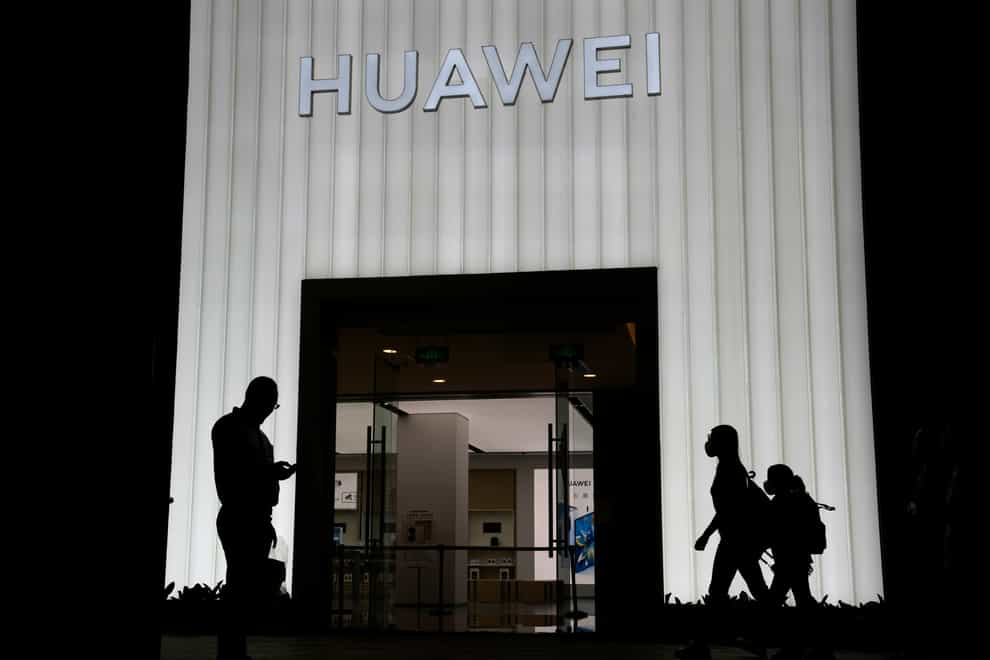 FILE – Shoppers pass by a Huawei store in Beijing, China, Thursday, Aug. 26, 2021. Two suspected Chinese intelligence officers have been charged with attempting to obstruct a criminal investigation and prosecution of Chinese tech giant Huawei, according to court documents unsealed Monday, Oct. 24, 2022. (AP Photo/Ng Han Guan, File)