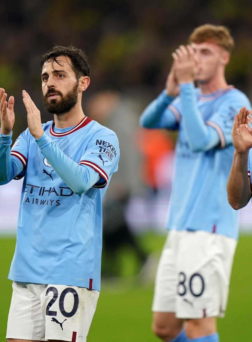 Manchester City’s Bernardo Silva and Julian Alvarez applaud their fans after their goalless draw in Dortmund (Tim Goode/PA)