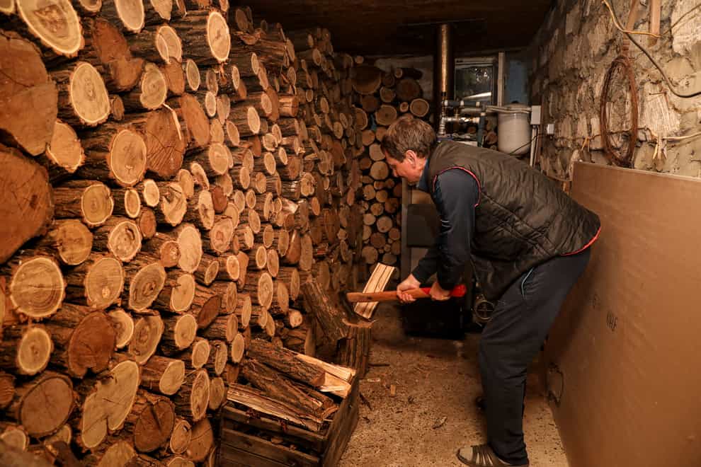 Tudor Popescu chops fire wood he uses for heating in a storage room attached to his home in Chisinau, Moldova (AP Photo/Aurel Obreja)