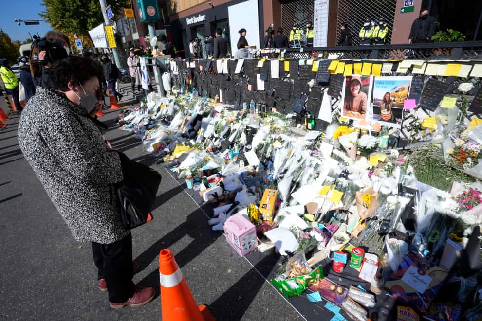 A woman pays tribute to victims of the incident during Saturday night’s Halloween festivities (Ahn Young-joon/AP)