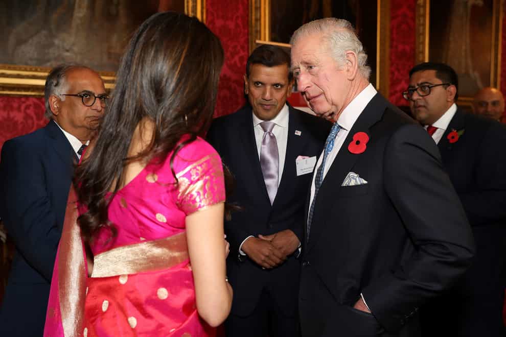 The King speaks with guests during a reception and ceremony commemorating the 50th anniversary of the Resettlement of British Asians from Uganda in the UK, at Buckingham Palace in London (Isabel Infantes/PA)