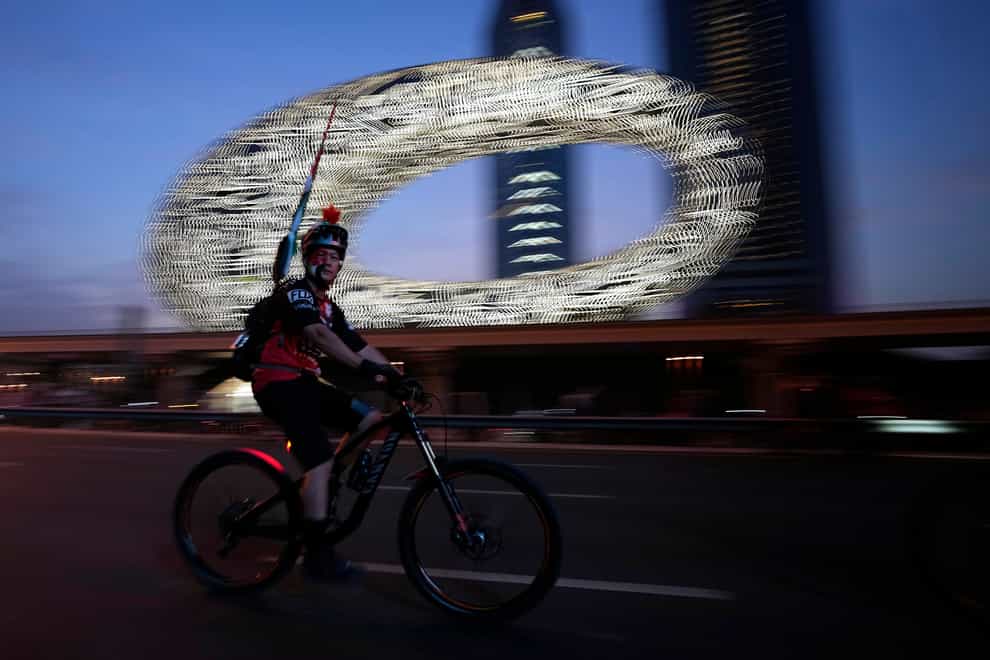 A cyclist rides past the Museum of the Future, in Dubai, United Arab Emirates (Kamran Jebreili/AP)