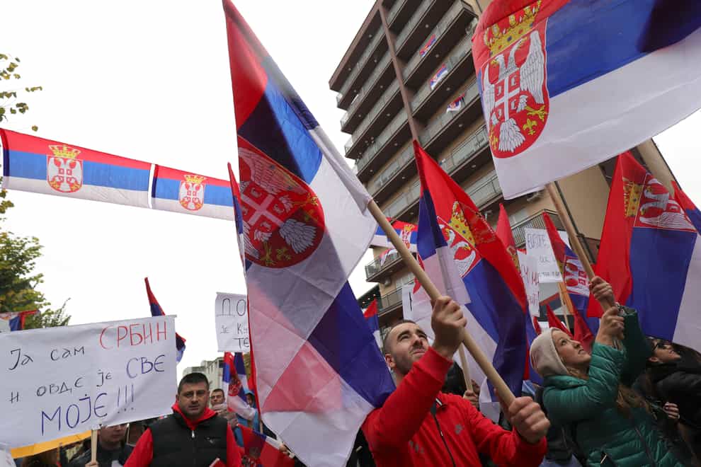 Ethnic Serbs in Kosovo wave Serbian flags during a protest in Mitrovica, Kosovo (Bojan Slavkovic/AP)