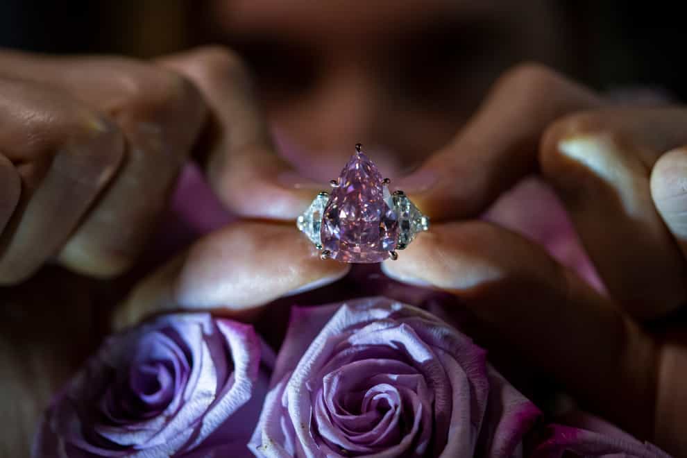 A Christie’s employee displays a pink diamond called The Fortune Pink of 18,18 carat, during a preview at Christie’s, in Geneva, Switzerland (Martial Trezzini/Keystone/AP)