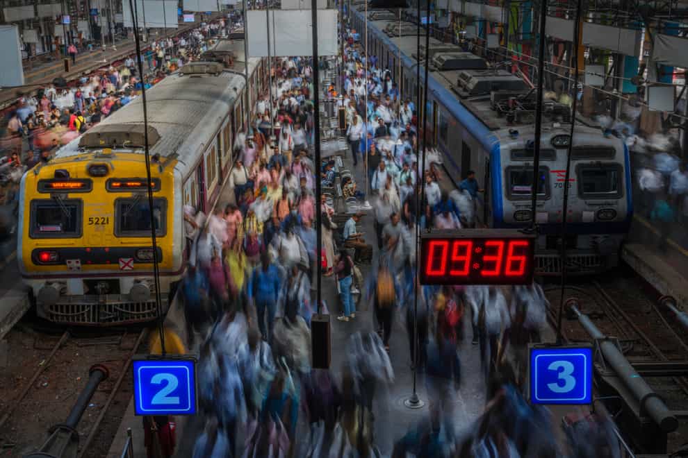 Indian commuters get off trains at the Church Gate railway station in Mumbai, India, Monday, Nov. 14, 2022 as the eight billionth baby on Earth is about to be born (Rafiq Maqbool/AP/PA)