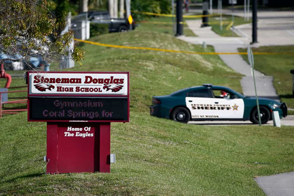 Police officers block off the entrance to Marjory Stoneman Douglas High School in Parkland, Fla., the day after a deadly shooting at the school (Wilfredo Lee/AP/PA)