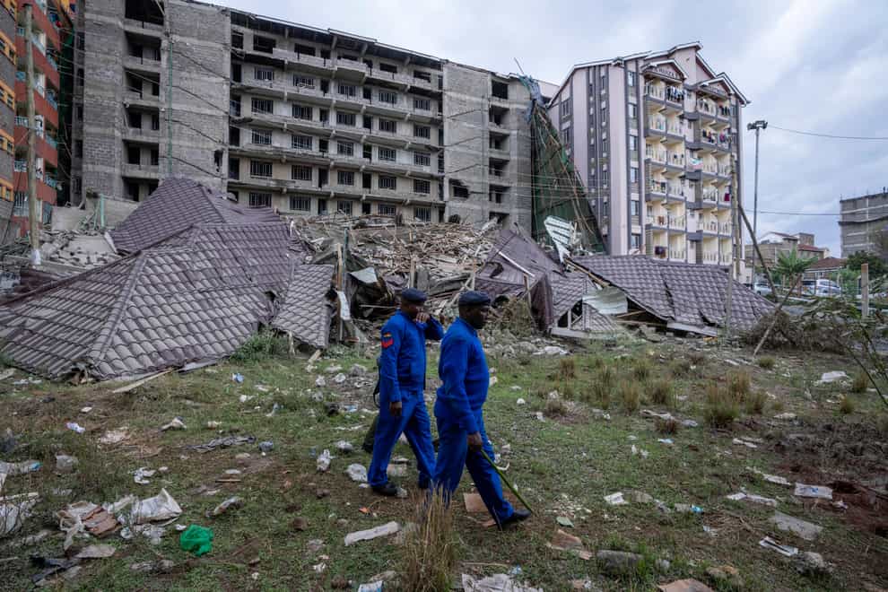 Policemen patrol at the scene of a building collapse in the Kasarani neighborhood of Nairobi, Kenya Tuesday, Nov. 15, 2022. Workers at the multi-storey residential building that was under construction are feared trapped in the rubble and rescue operations have begun, but there was no immediate official word on any casualties. (AP Photo/Ben Curtis)