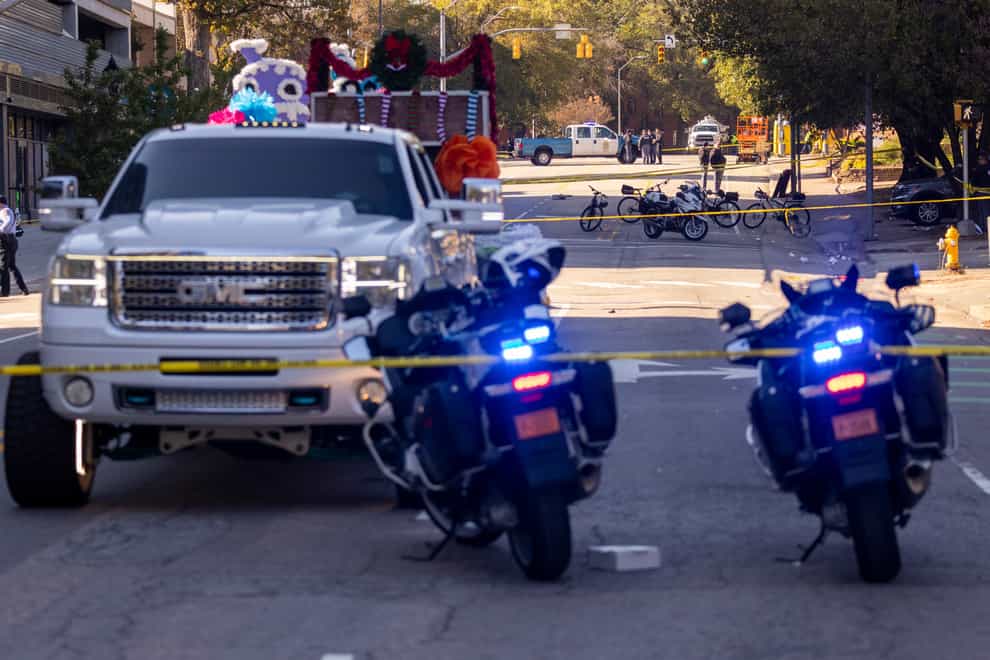 Police officers work the scene in Raleigh, North Carolina after a truck pulling a float crashed at a holiday parade (Travis Long/The News & Observer via AP/PA)