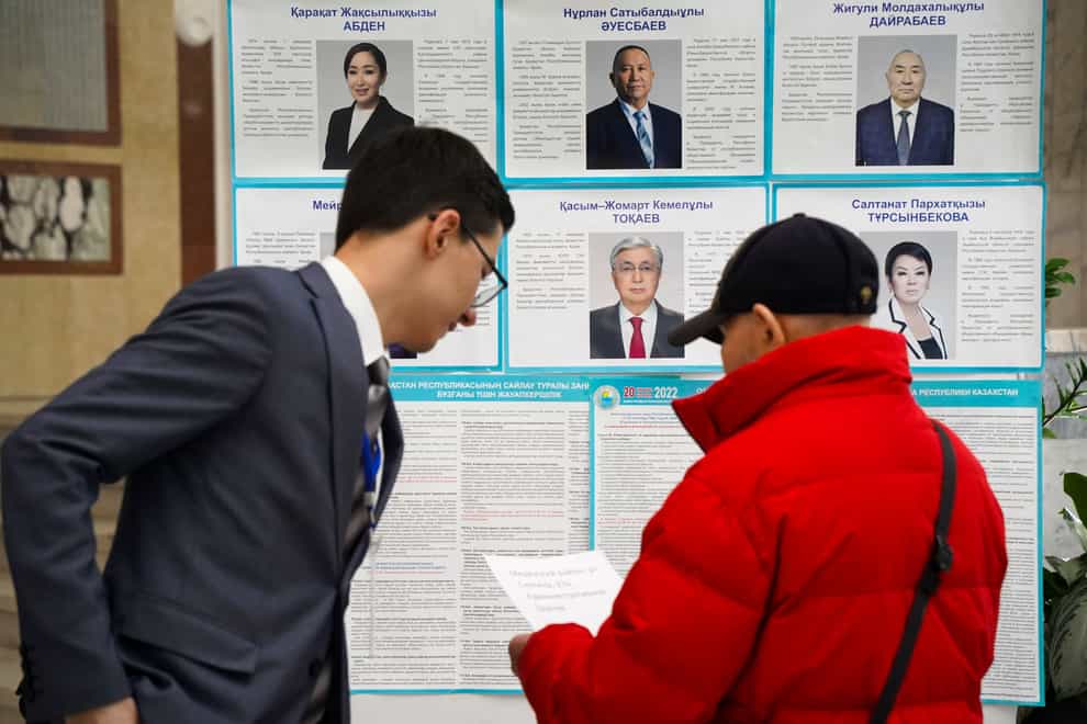 A member of the election commission speaks to a voter at a polling station in Almaty, Kazakhstan (Vladimir Tretyakov/NUR.KZ/AP)