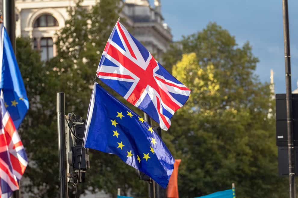A Union flag and EU flag outside the Houses of Parliament, London (Steve Parsons/PA)