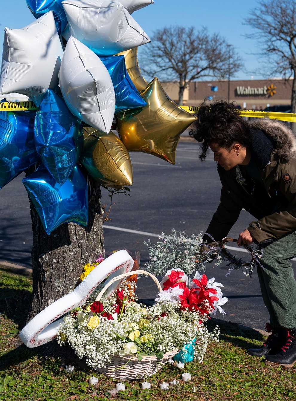 A passer-by places flowers near the Walmart store where six people were shot dead (AP Photo/Alex Brandon)