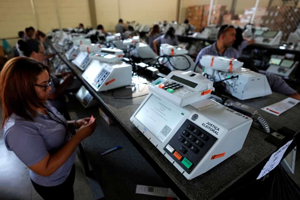 Electoral Court employees work on the final stage of sealing electronic voting machines in preparation for the general election run-off in Brasilia, Brazil (AP)