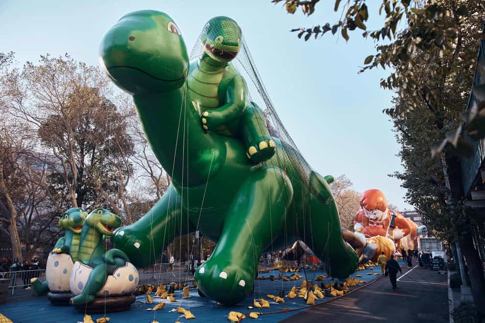 Police walk by an inflated helium balloon of Sinclair’s Dino (Andres Kudacki/AP)