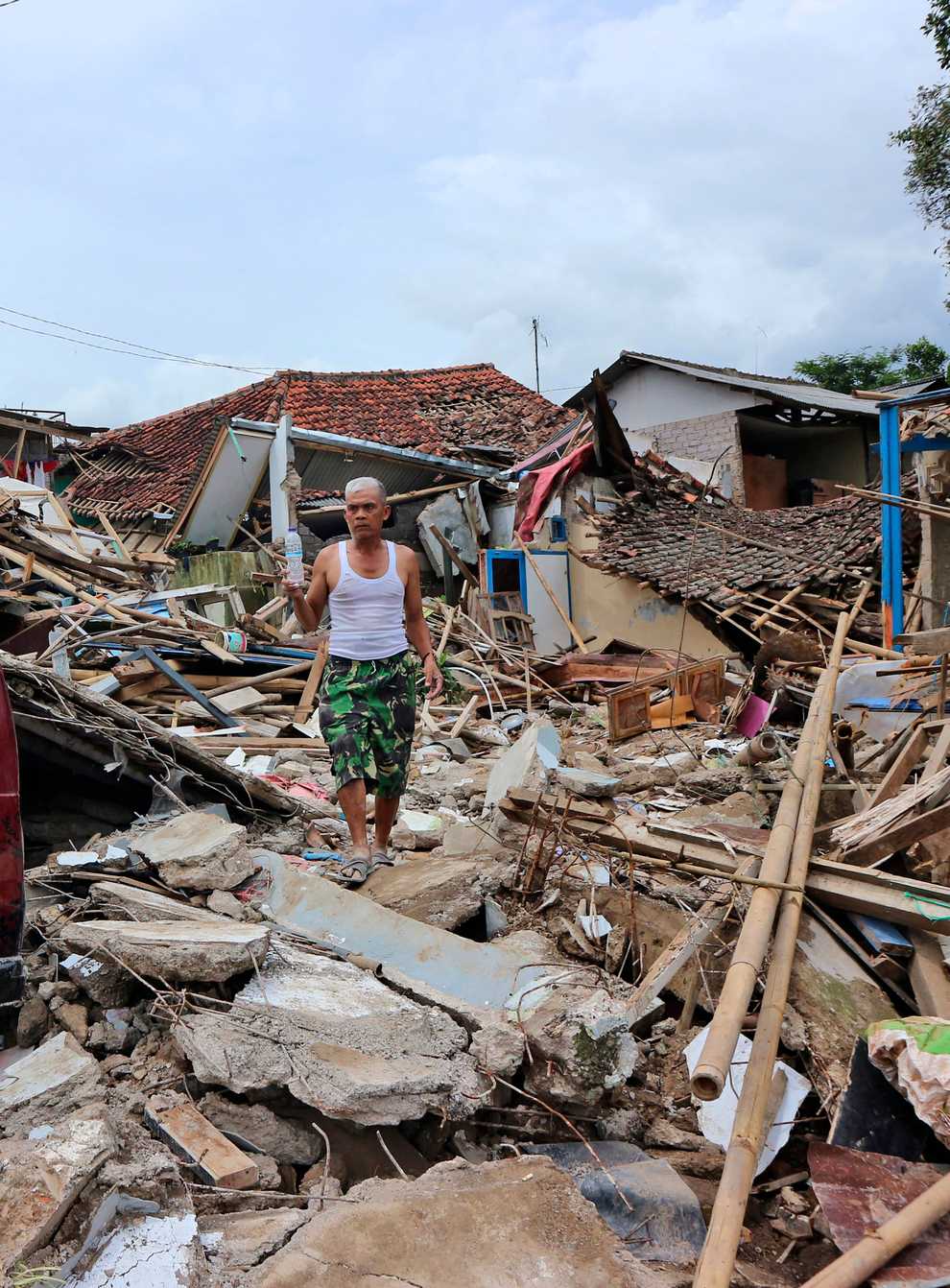 A man walks on the rubble of houses in a neighbourhood heavily affected by Monday’s earthquake in Cianjur, West Java, Indonesia (Rangga Firmansyah/AP)