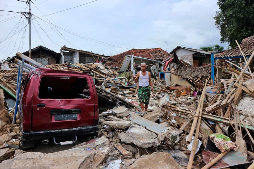 A man walks on the rubble of houses in a neighbourhood heavily affected by Monday’s earthquake in Cianjur, West Java, Indonesia (Rangga Firmansyah/AP)