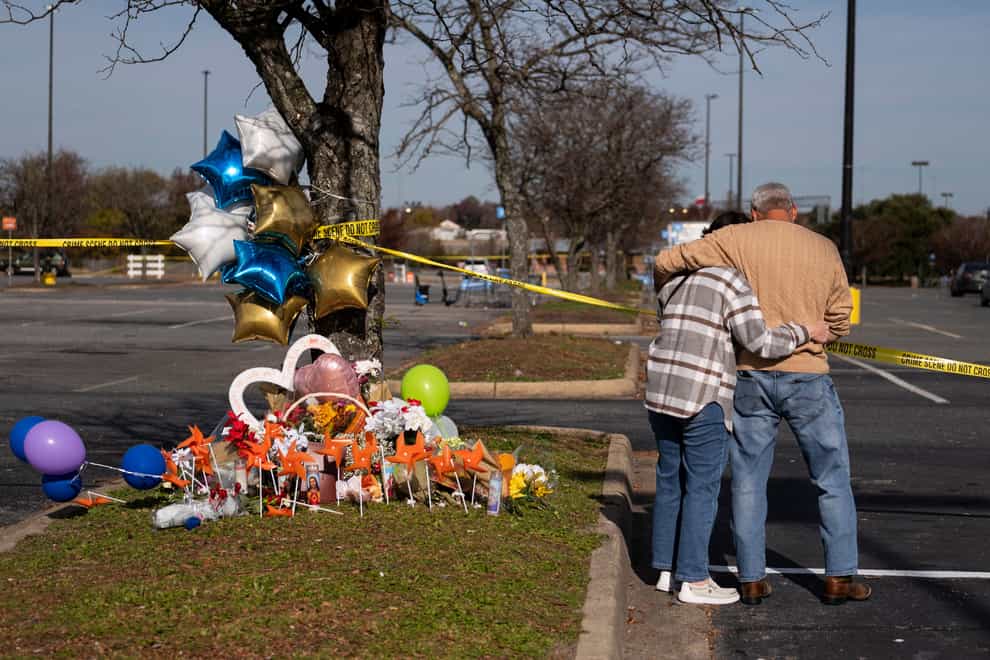 Two bystanders place flowers near the Walmart store (Billy Schuerman/The Virginian-Pilot via AP)